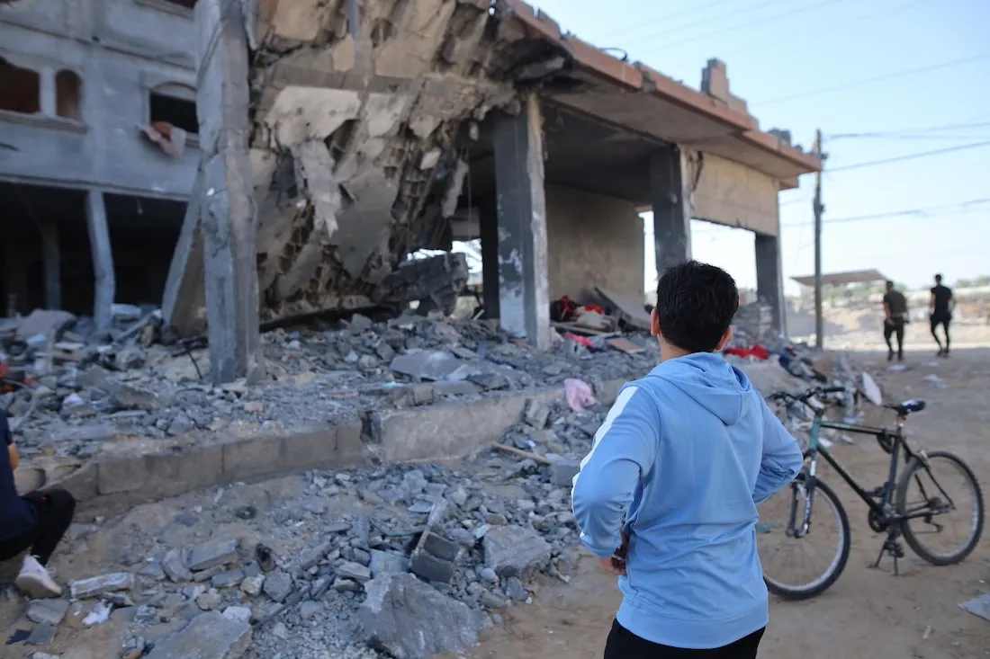back of boy looking at rubble in Gaza