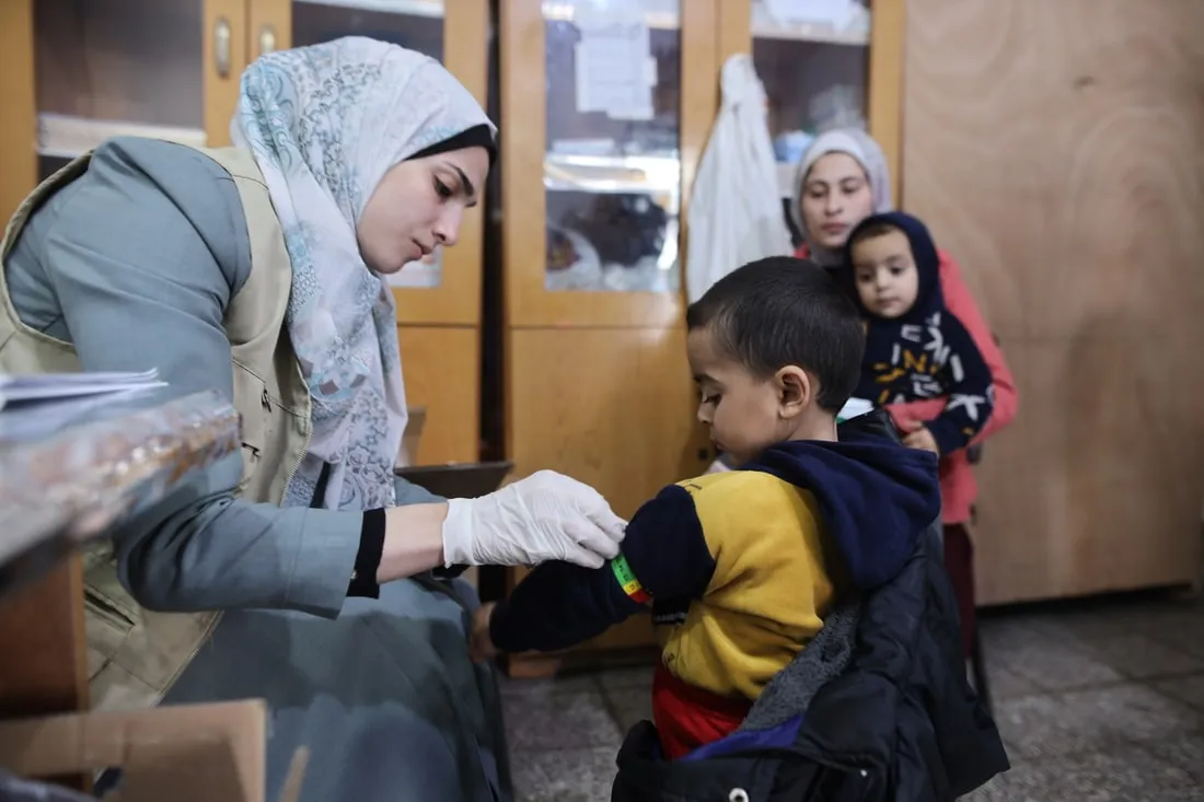 medical staff checking young boy for malnutririon
