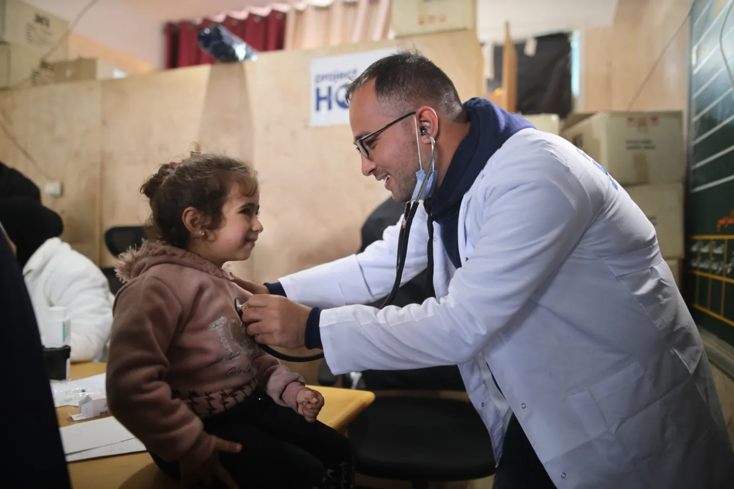 doctor checks heartbeat of young girl with stethoscope