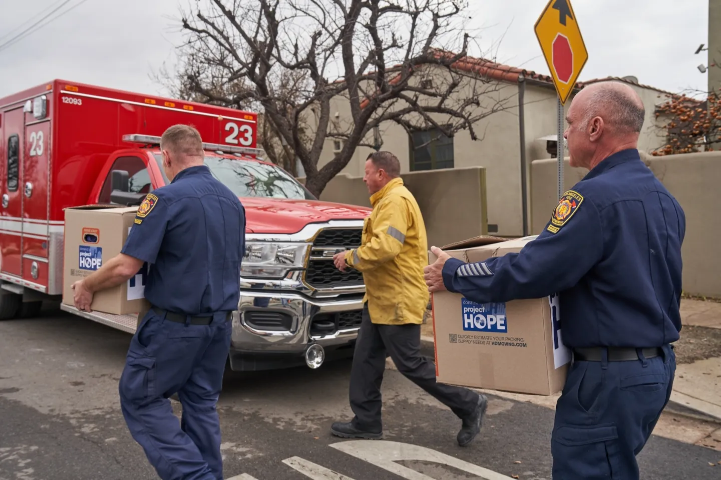 firefighters carry boxes to a truck