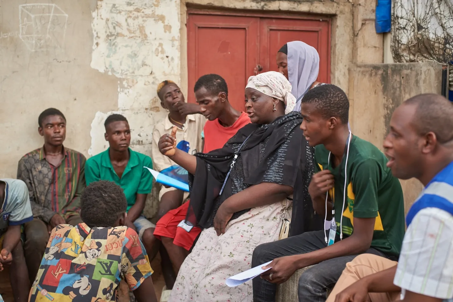 Motherly woman, speaks to young men about mental health in Nigeria