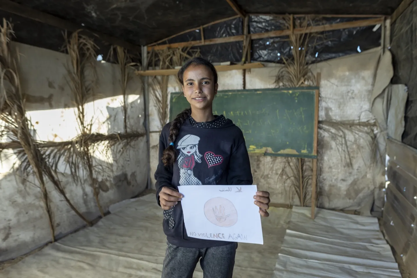 young girl with her painting in Gaza camp