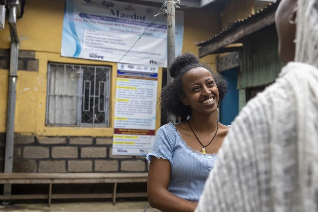 Black woman with blue shirt smiles