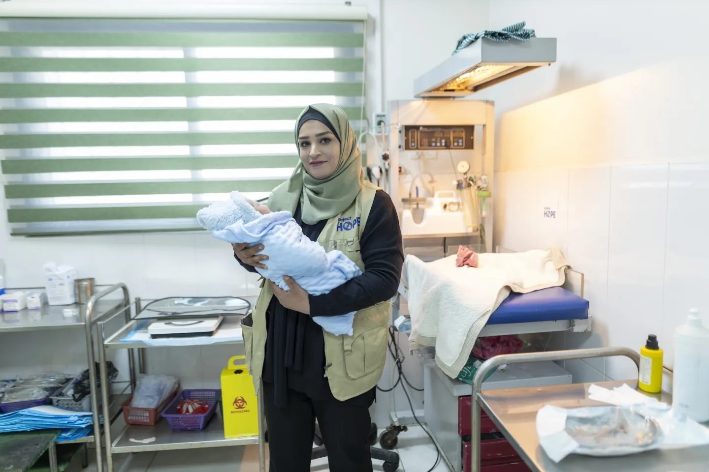 Midwife in Gaza holding newborn baby