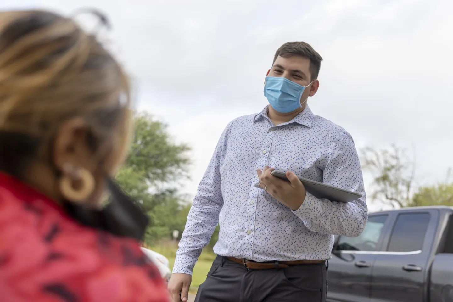man in mask speaking to woman