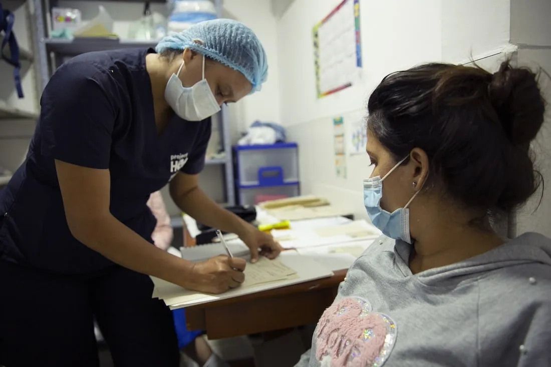 Medical staff writes down medical information of patient