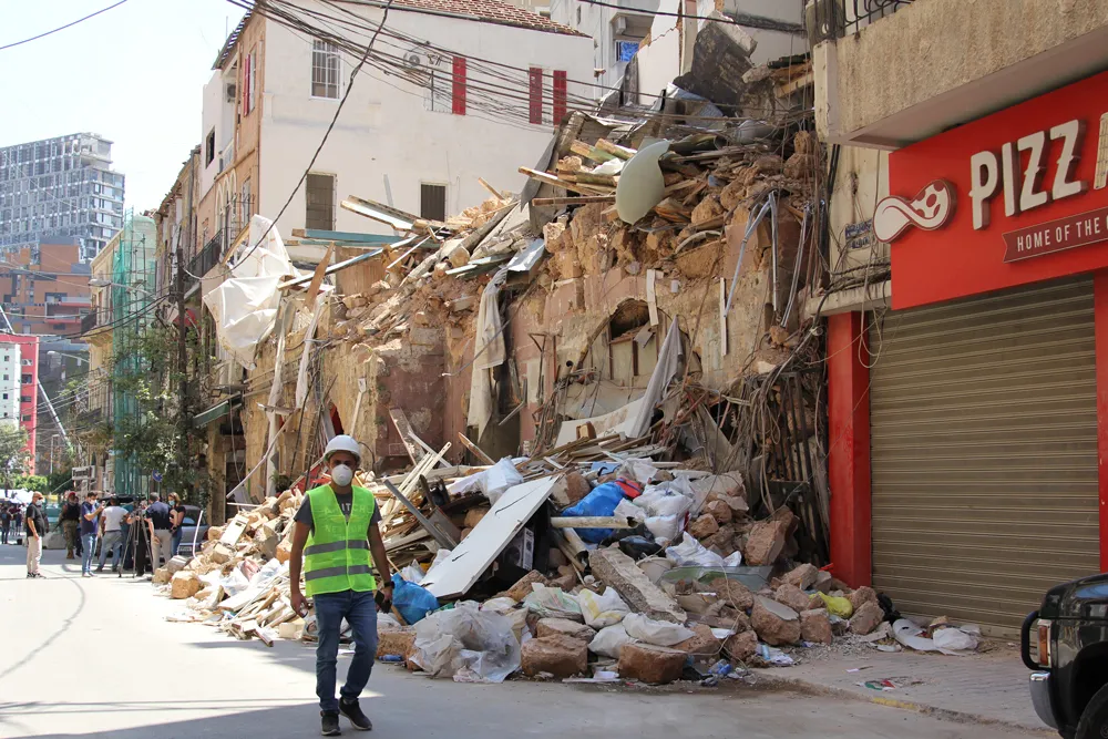 man walks along destruction in Beirut, Lebanon