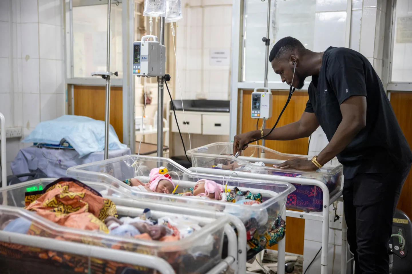 doctor uses stethoscope to check on newborns