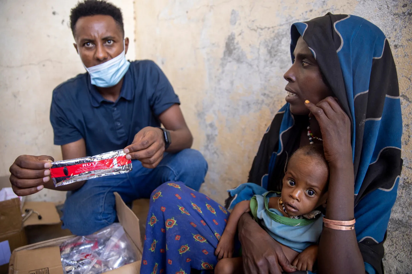 man with nutritional bar sitting with mother and baby