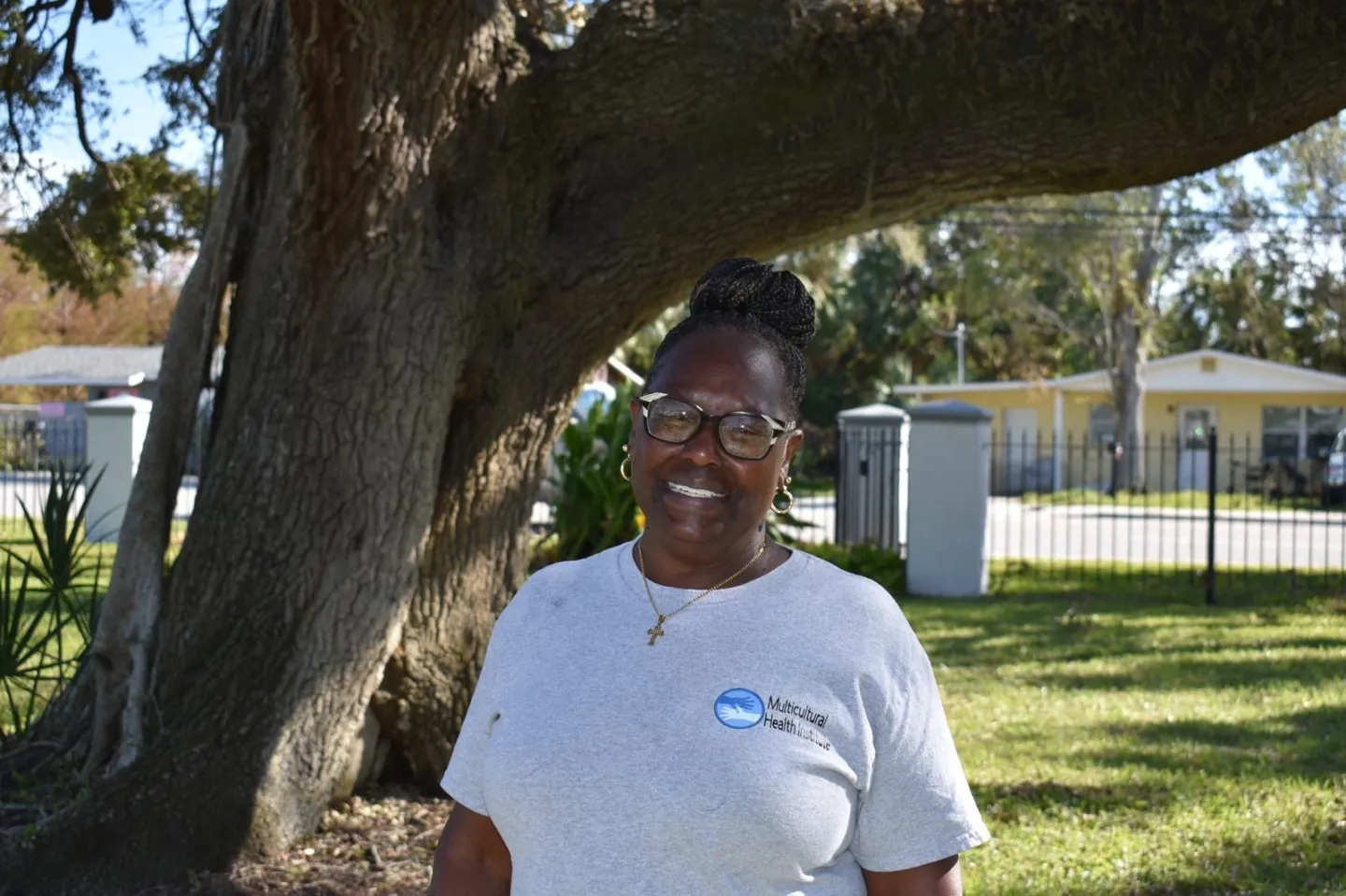 woman poses in front of tree