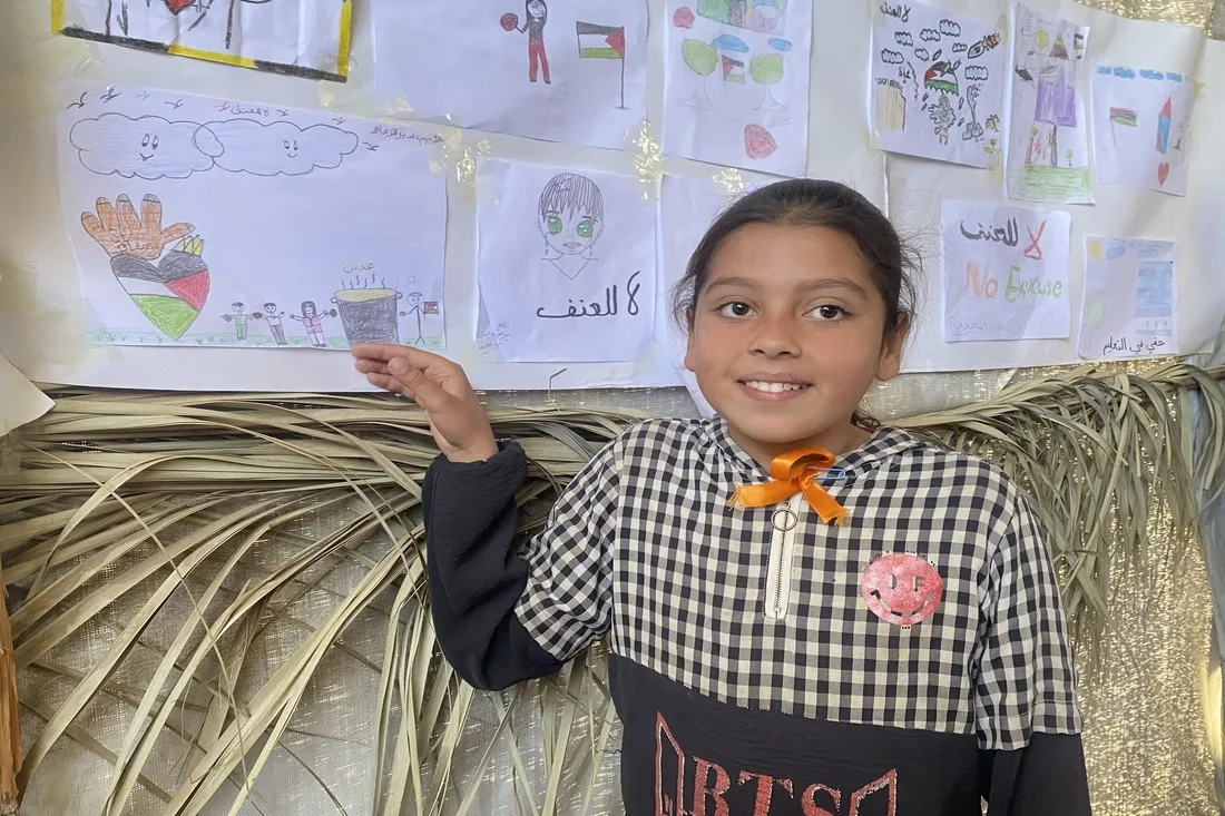 Young girl in Gaza camp showing off her artwork