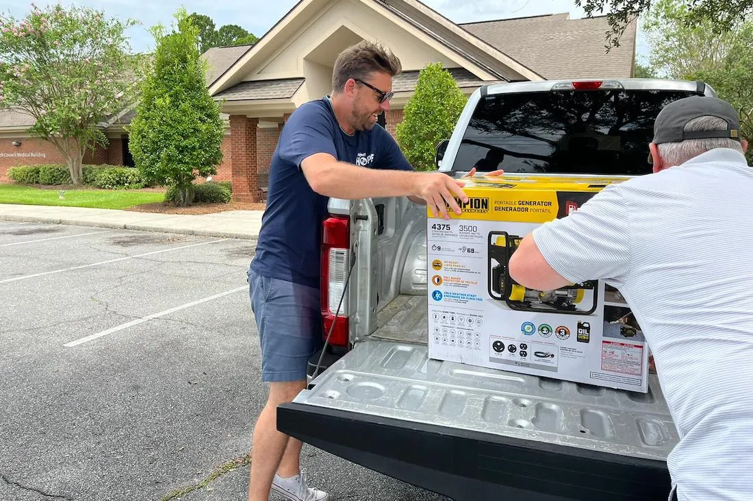 man unloading generator from truck
