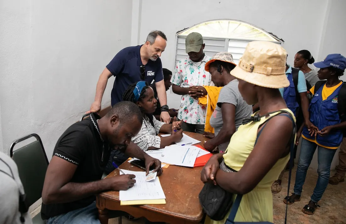 group of people around a table speaking.