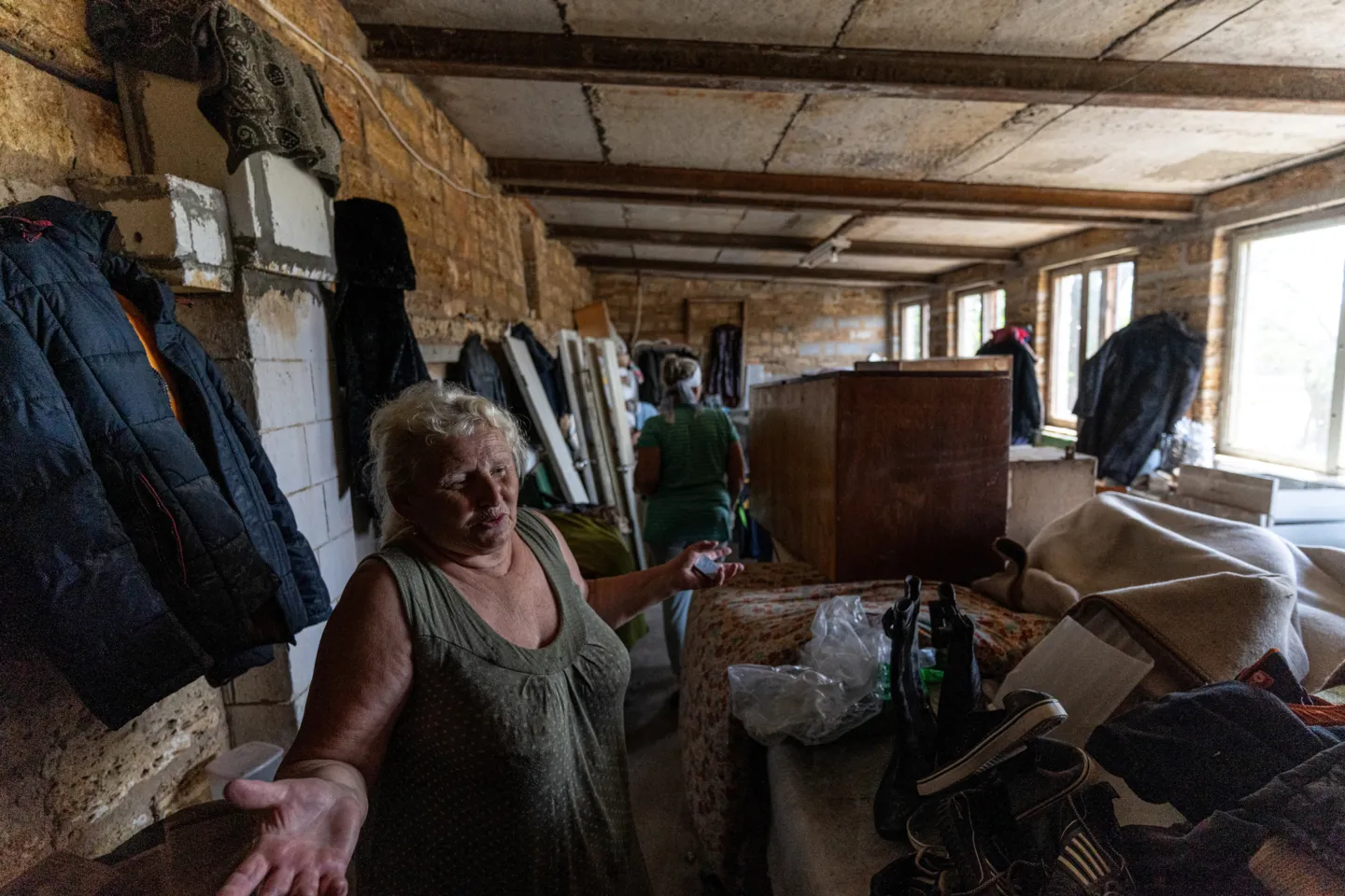 woman standing inside house damaged by floods