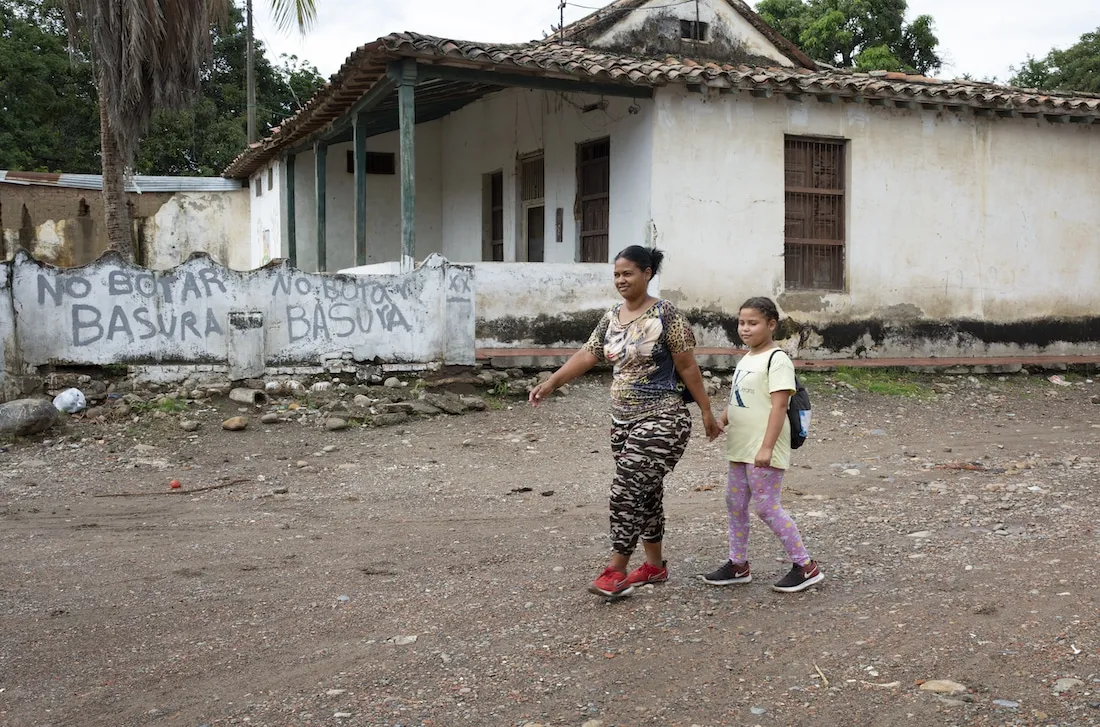 Woman and daughter walking in village