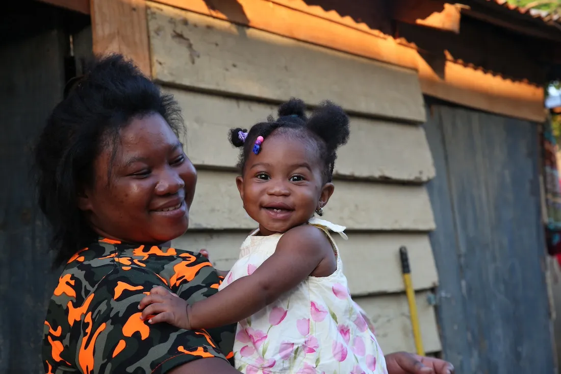Young baby girl smiling as her mother holds her