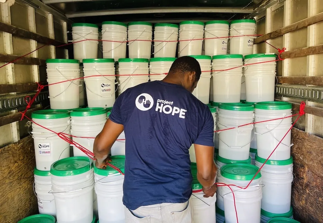 back of man loading hygiene kits into truck.