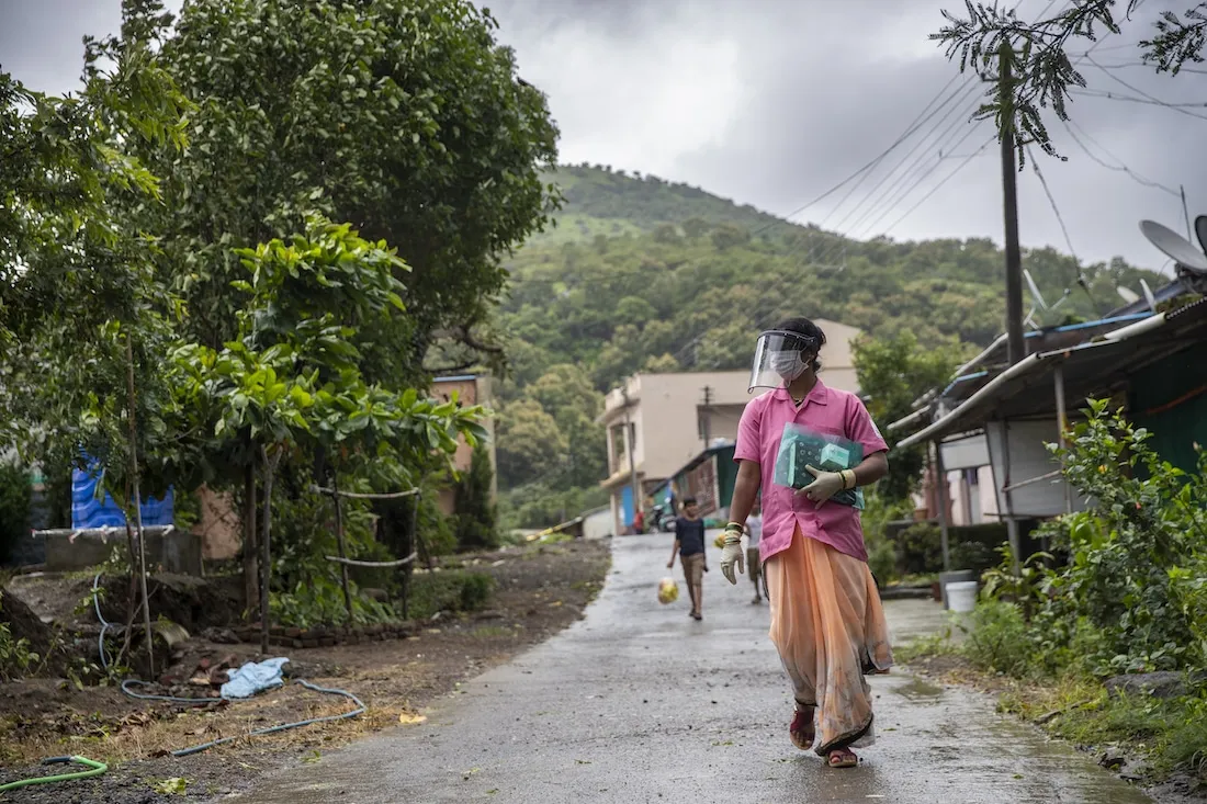 Woman in PPE walks down street