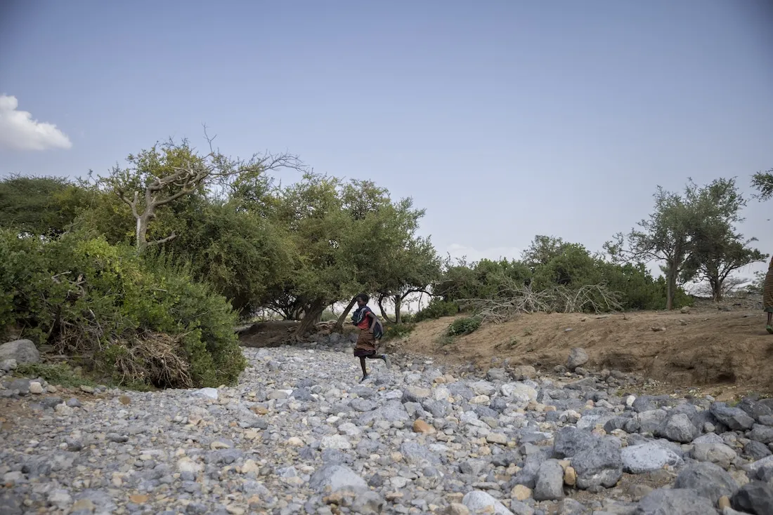 young child runs across dried up river