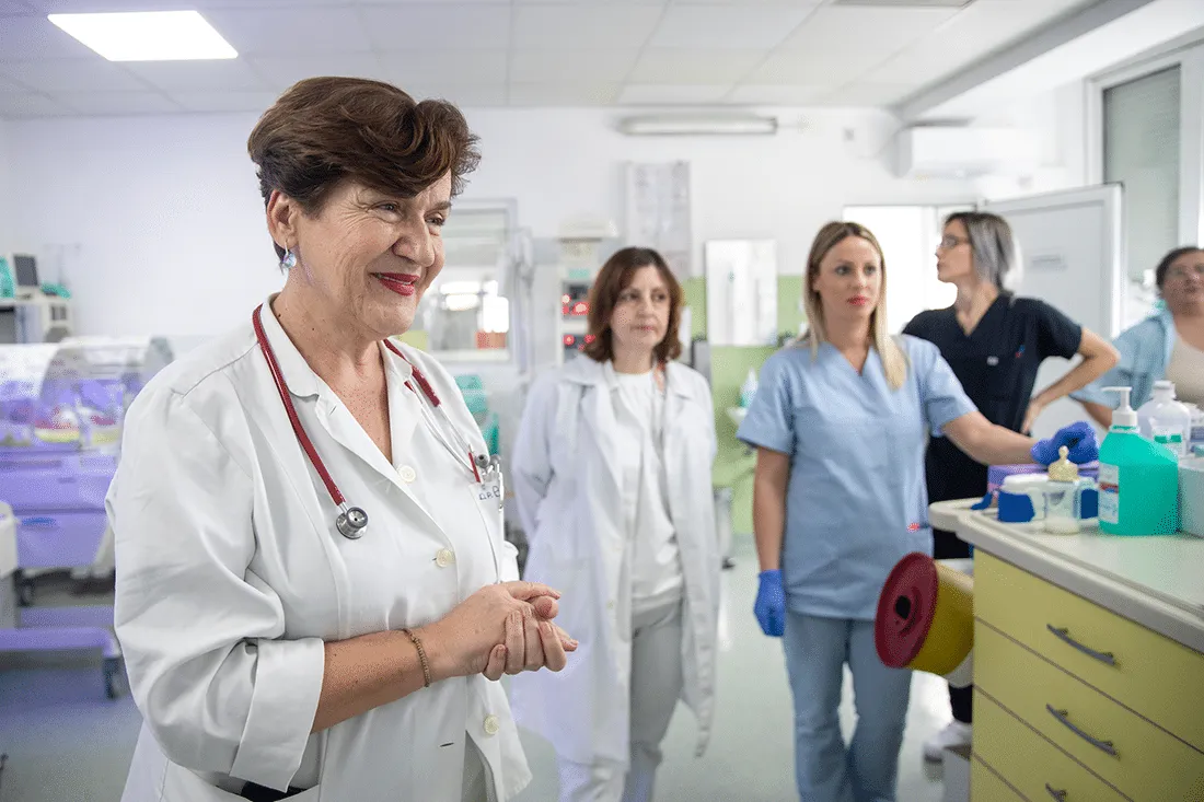 Doctor in NICU ward teaching nurses.