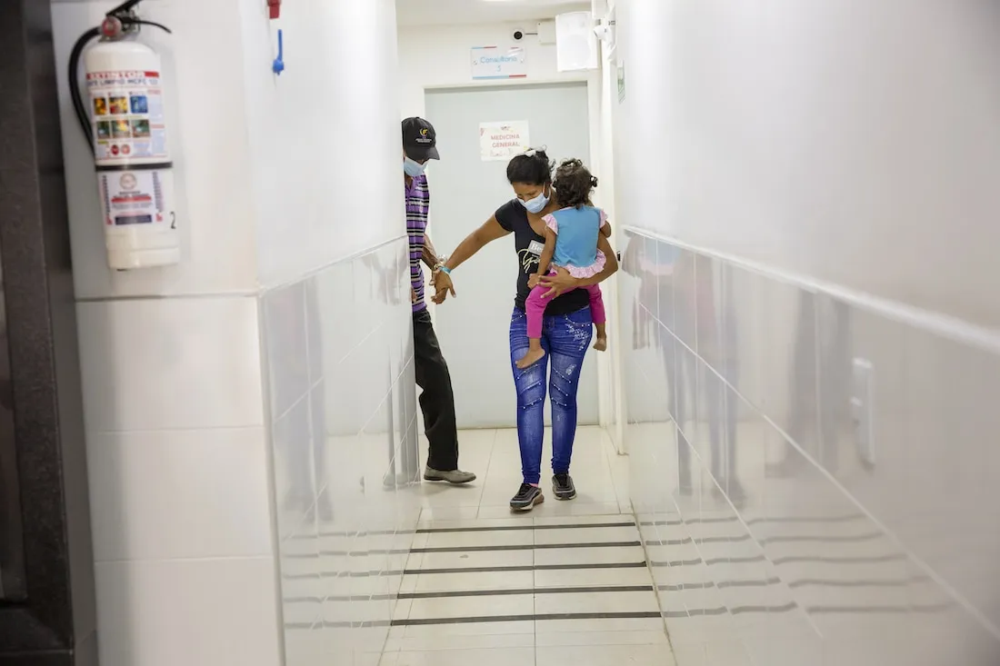 a family walking down a hallway wearing masks
