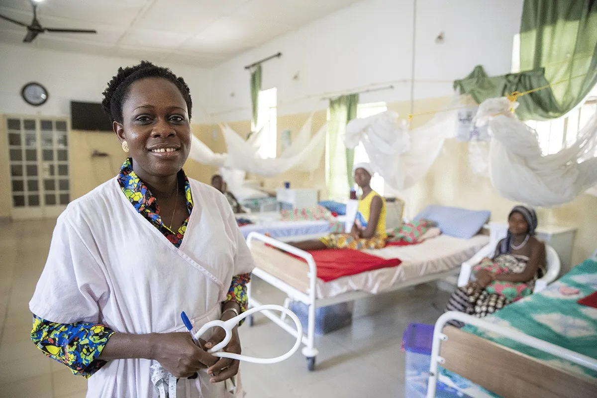 Nurse standing in hospital room with patients