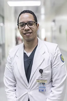 male doctor wearing a white coat and scrubs
