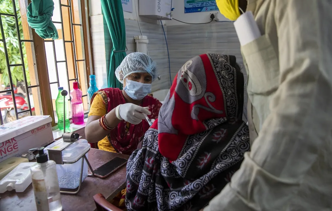 health worker gives COVID-19 vaccine to patient