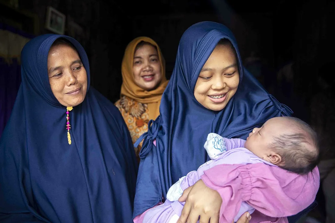 Three midwives with a newborn