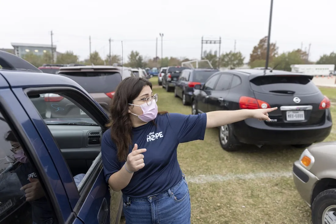 woman in facemask directs cars