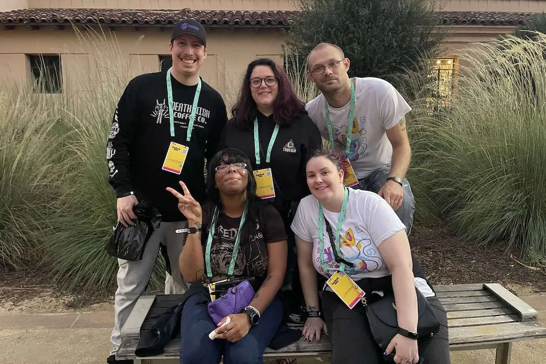 group of five people posing together and smiling at the camera