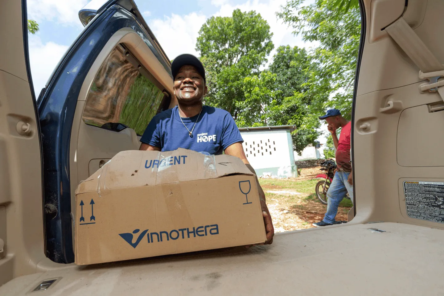 woman carries box of supplies to clinic