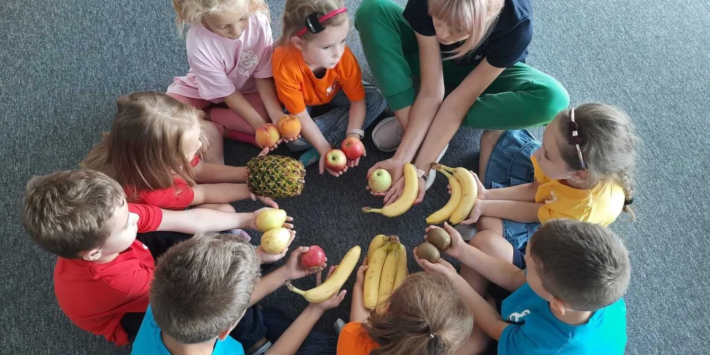 children holding fruit in a circle