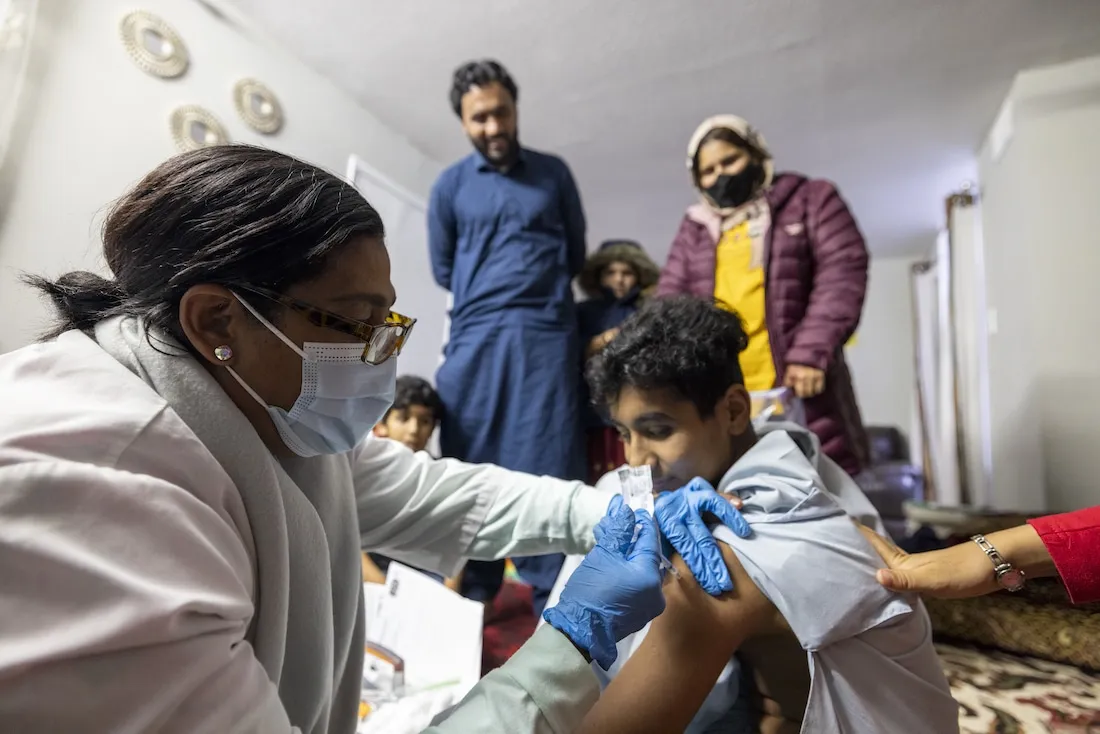 medical doctor gives COVID-19 vaccine to young patient