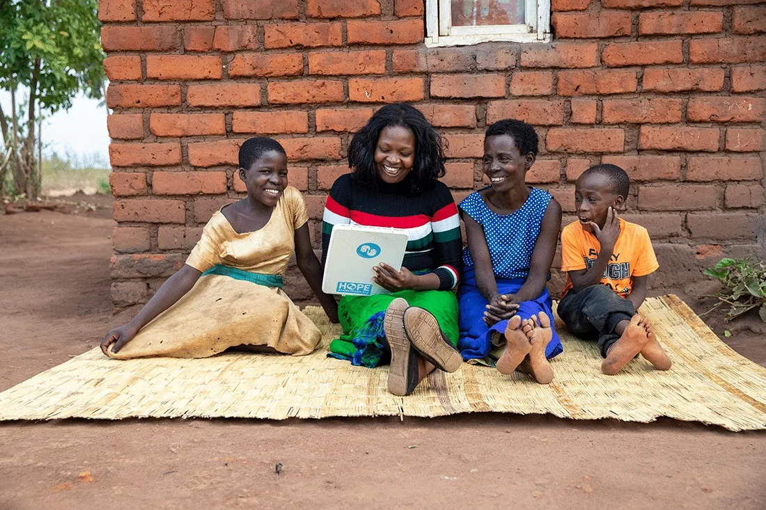Four people sitting on a blanket