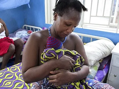 mother holding newborn to chest for comfort.