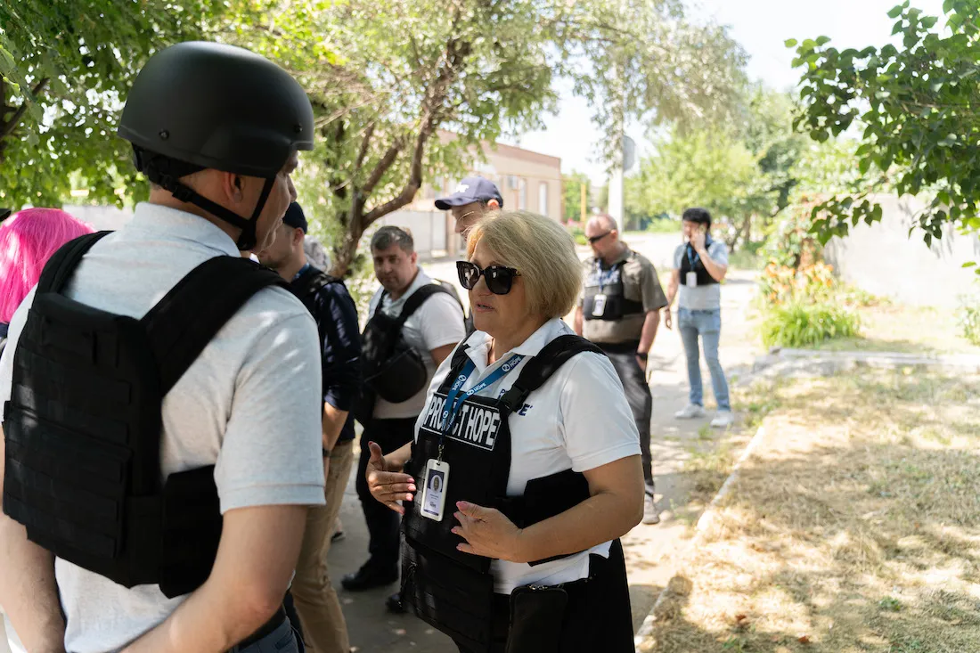 woman in protective gear speaking to man in protective gear